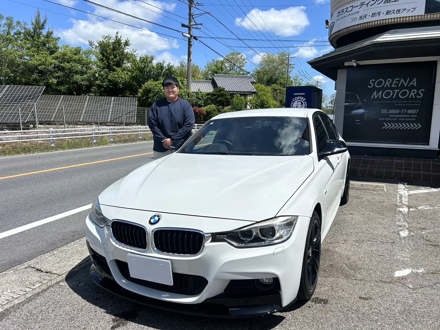店先でBMWと並ぶ人たち