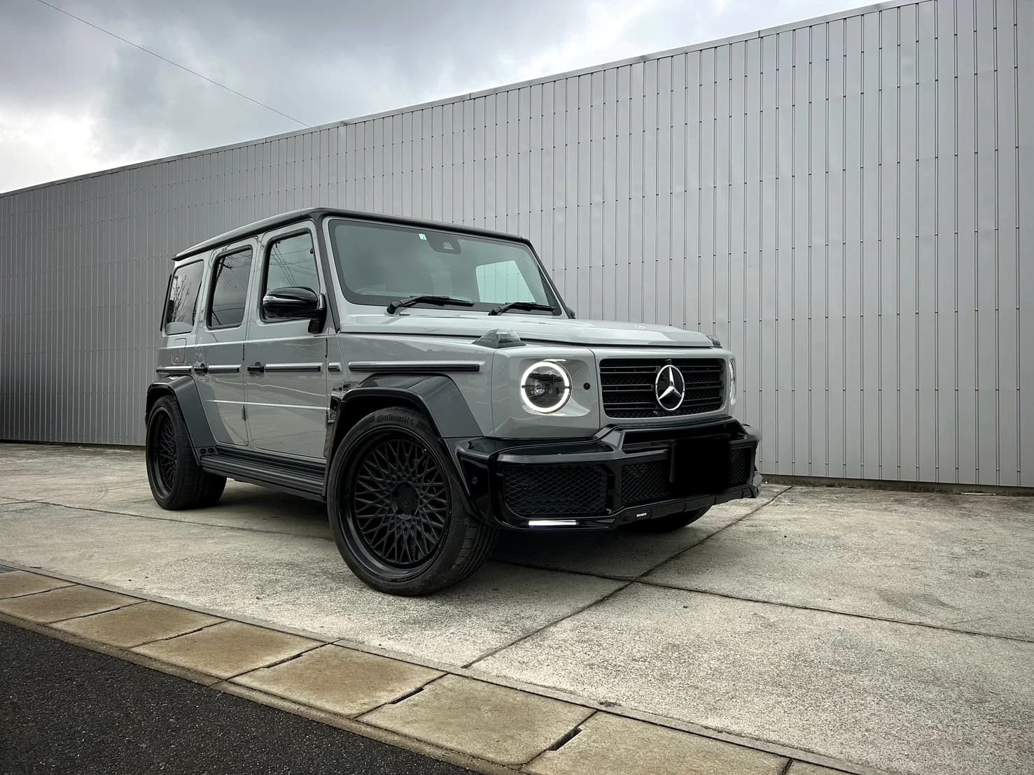 グレーのボディと黒いホイールのメルセデス・ベンツ Gクラス